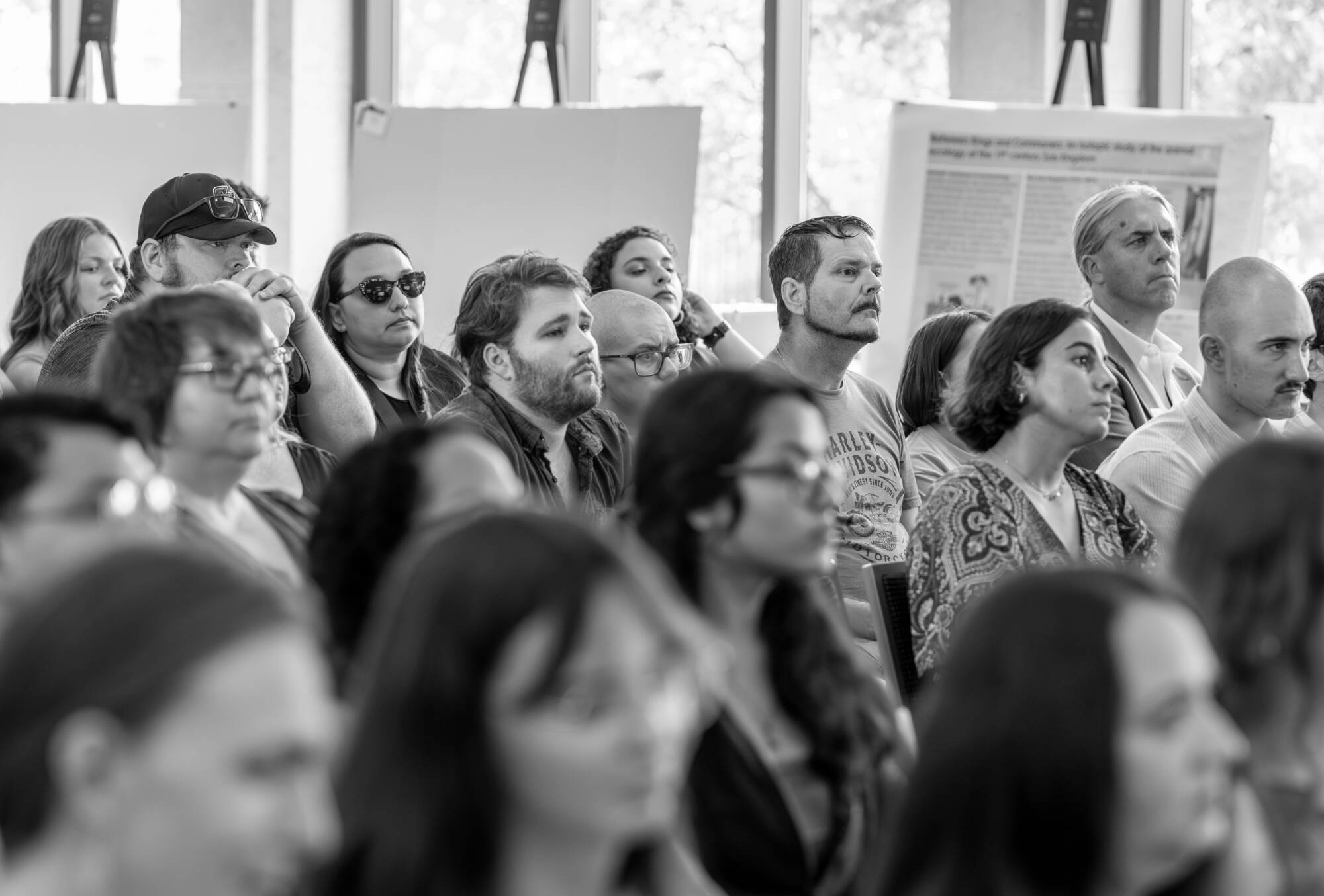 A crowd listens to student presentations at the 2025 Summer Scholars Showcase.